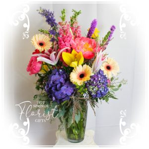 A vibrant bouquet of assorted flowers arranged in a glass vase.