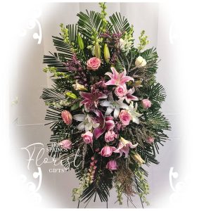 An elegant floral arrangement featuring a mix of pink roses, white lilies, and assorted greenery, suitable for a formal event or as a sophisticated gift.