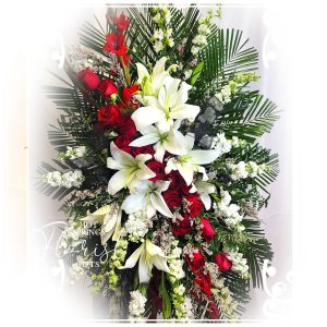 An elegant floral arrangement featuring red roses and white lilies.