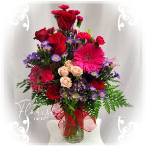 A Bright Birthday Bundle with red roses, pink blossoms, and purple accents.