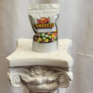 A bag of Candeeze Freeze Dried Candy displayed on a decorative white pedestal.