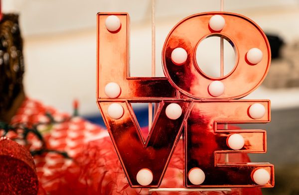 A red neon "love" sign with illuminated bulbs.