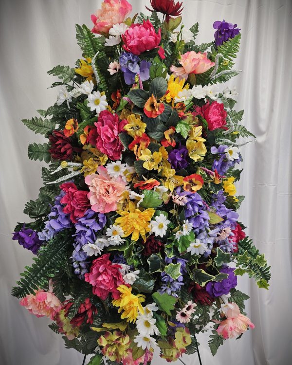 A vibrant arrangement of assorted artificial flowers against a neutral backdrop.