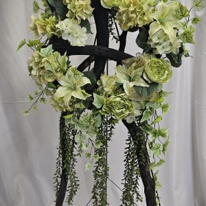 Floral arrangement with green hydrangeas displayed on a wooden easel.