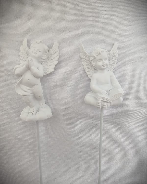 The Double Sympathy Angel Picks feature two white angel figurines on sticks against a white textured background; one angel is standing with hands clasped, while the other is seated with an open book.